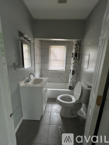 A small bathroom with a toilet, sink, and window.