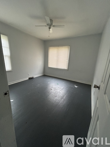 A room with a ceiling fan and a window.