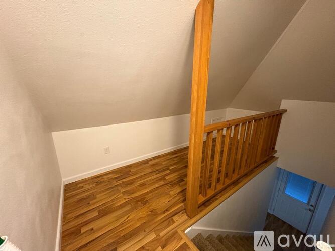 A wooden staircase with a railing leads up to a blue door.