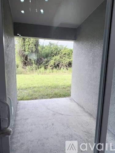 A view from inside a room looking out to a grassy area.