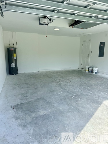 A spacious garage with a concrete floor and a white wall.