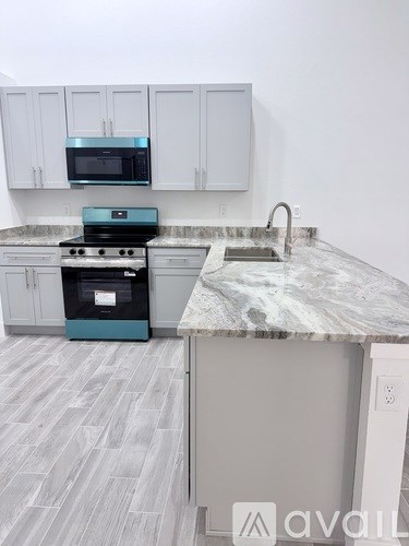 A kitchen with a marble countertop and a stove top oven.