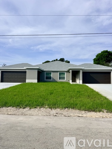 A house with a grey roof and a green lawn in front.