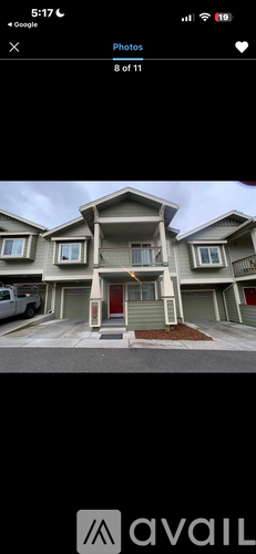 A two-story house with a red door and a balcony on the second floor.