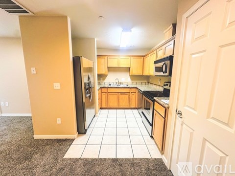 A kitchen with a refrigerator, microwave, and oven.