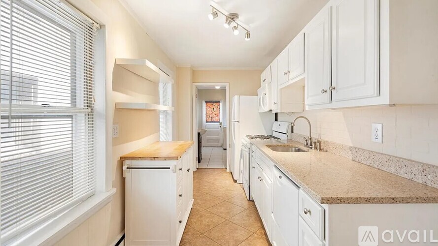 A kitchen with white cabinets and a countertop.