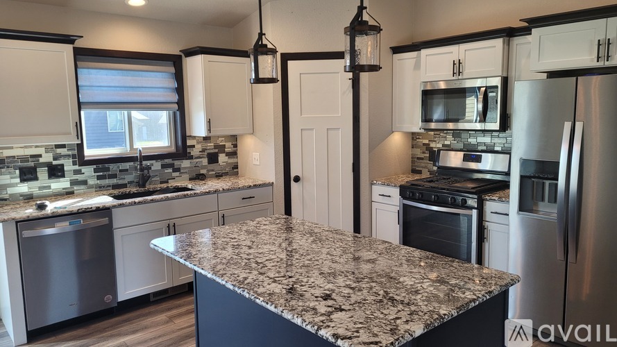 A kitchen with granite countertops and stainless steel appliances.