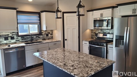 A kitchen with granite countertops and stainless steel appliances.