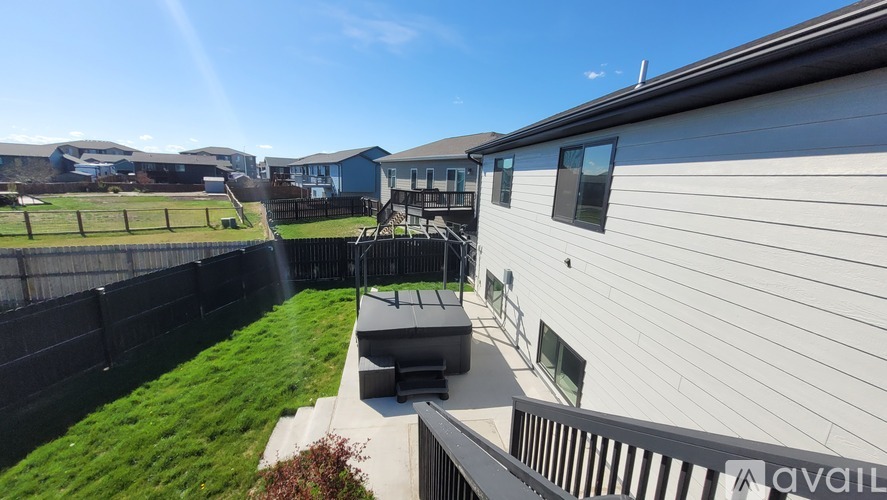 A house with a white exterior and a deck in front of it.