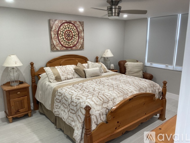 A bedroom with a large bed and a ceiling fan.