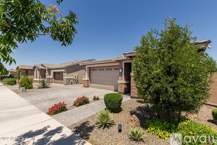 A house with a driveway and landscaping in front.