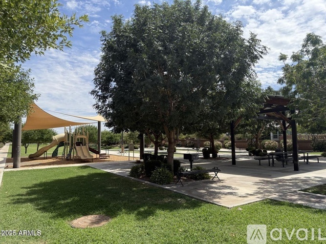 A park with a playground, picnic tables, and trees.