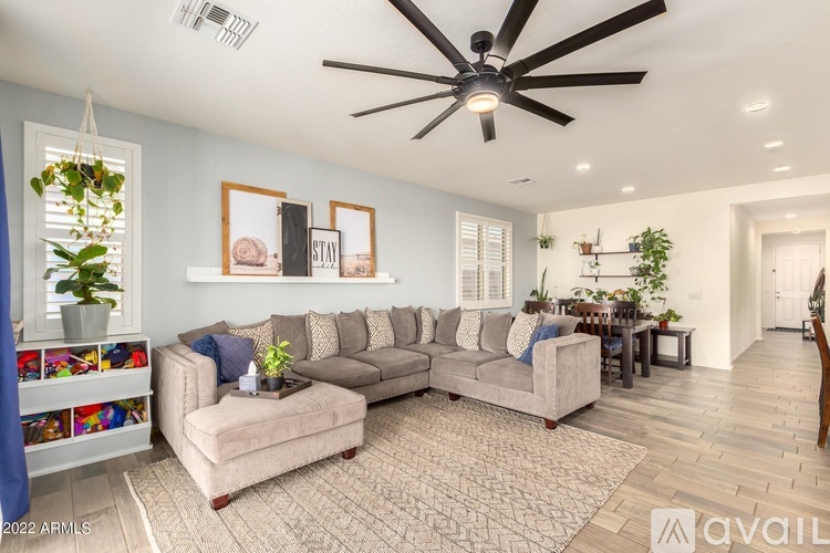 A living room with a grey couch, a coffee table, and a ceiling fan.