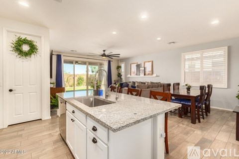 A kitchen with a large island and a dining table with chairs.