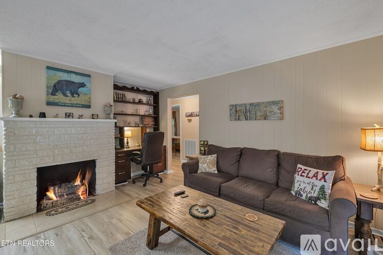 A living room with a fireplace and a brown couch.