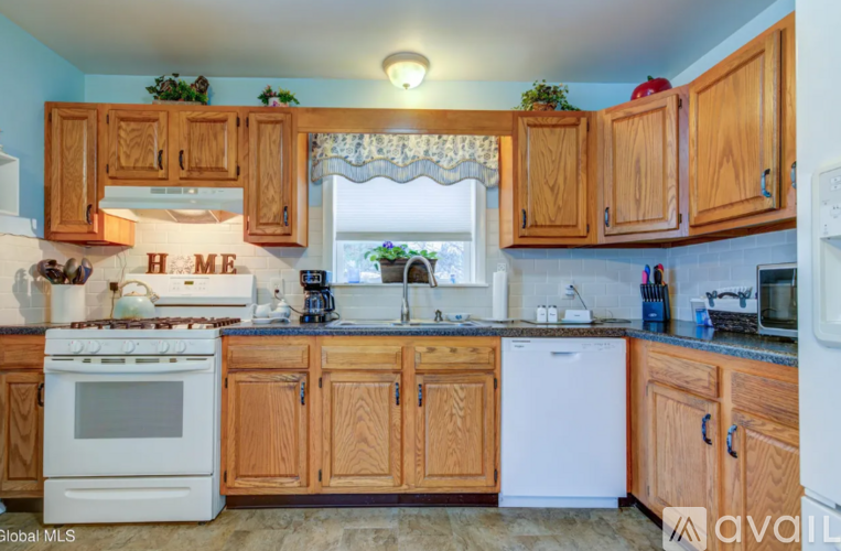 A kitchen with wooden cabinets and a white stove top oven.