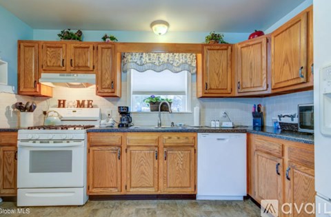A kitchen with wooden cabinets and a white stove top oven.