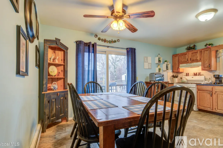 A dining room with a wooden table and chairs.