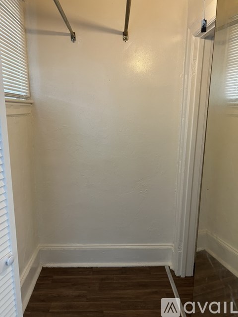 A white wall with a brown floor and a white door.