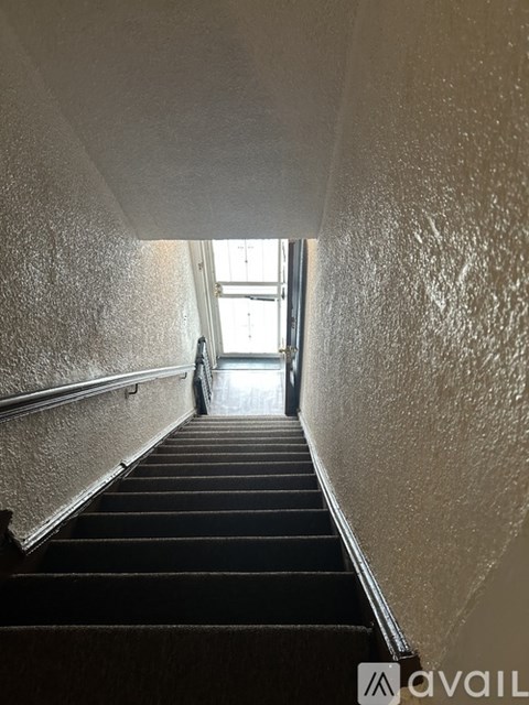 A staircase leading to a bright room with a window.