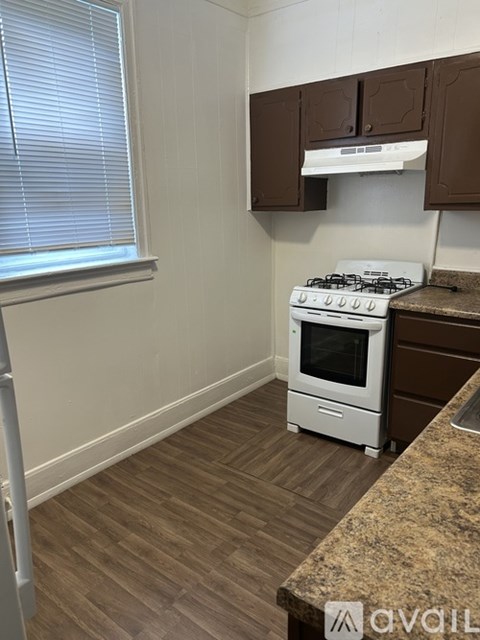 A white stove is in a kitchen with brown cabinets.