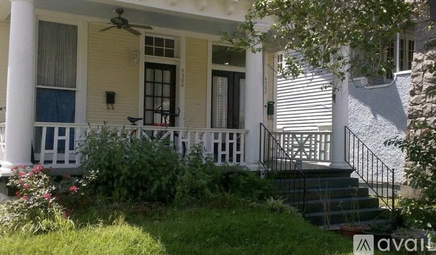 A house with a porch and a fan on the roof.