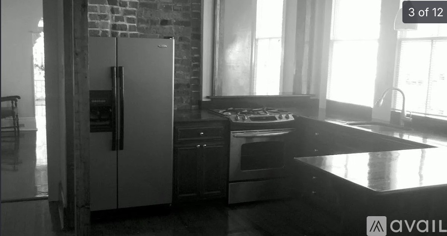 A kitchen with a refrigerator, oven, and sink.