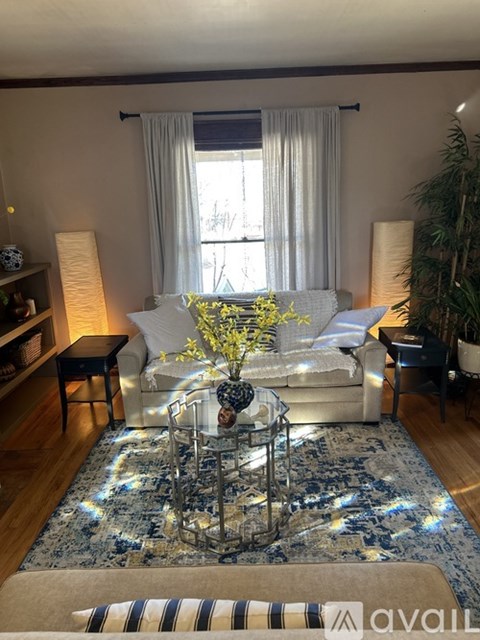 A living room with a white couch and a glass coffee table.