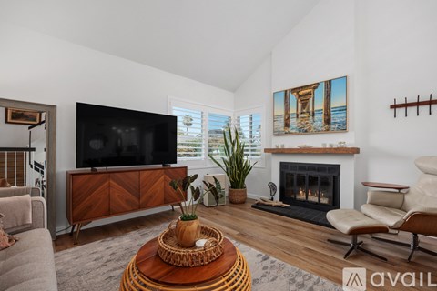 A living room with a fireplace and a painting on the wall.