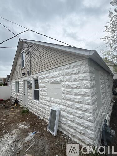 A house with a grey siding and a white door is shown.