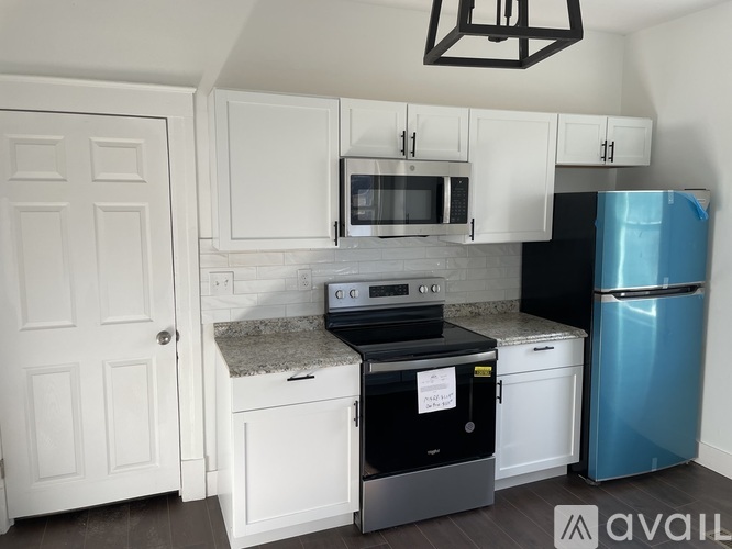 A kitchen with a white cabinet and a blue fridge.