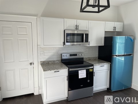 A kitchen with a white cabinet and a blue fridge.
