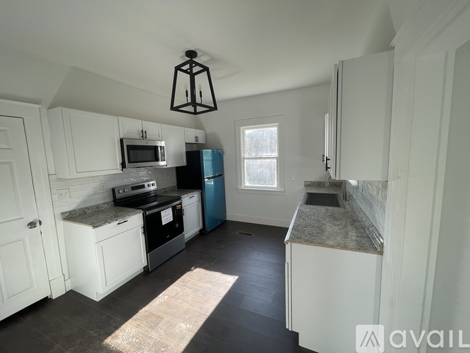 A kitchen with white cabinets and a granite countertop.