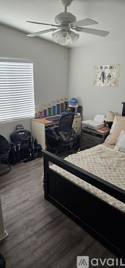 A bedroom with a bed, desk, and chair.