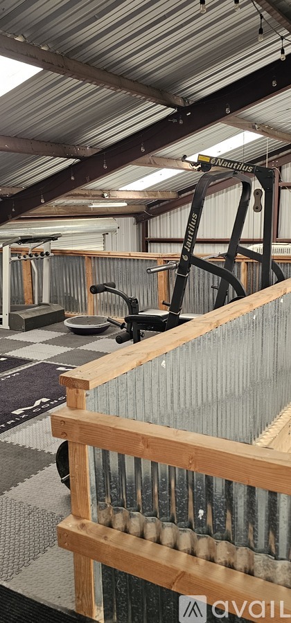 A gym with a weightlifting machine and a wooden railing.