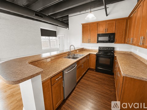A kitchen with wooden cabinets and a black stove top oven.