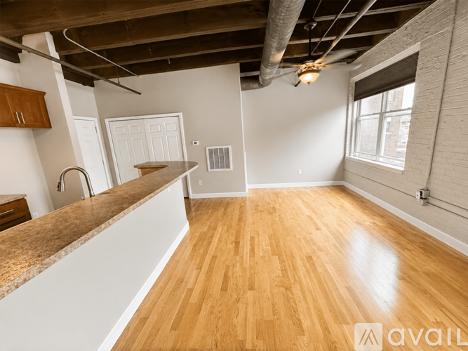 A spacious room with wooden flooring and a countertop.