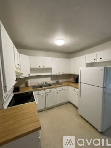 A kitchen with white appliances and cabinets.