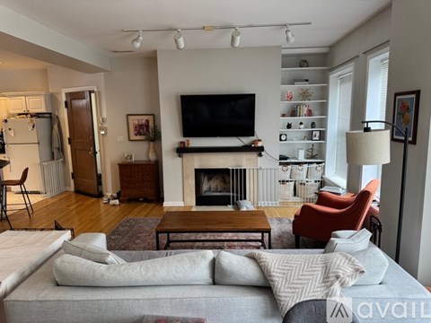 A living room with a grey couch and a fireplace.