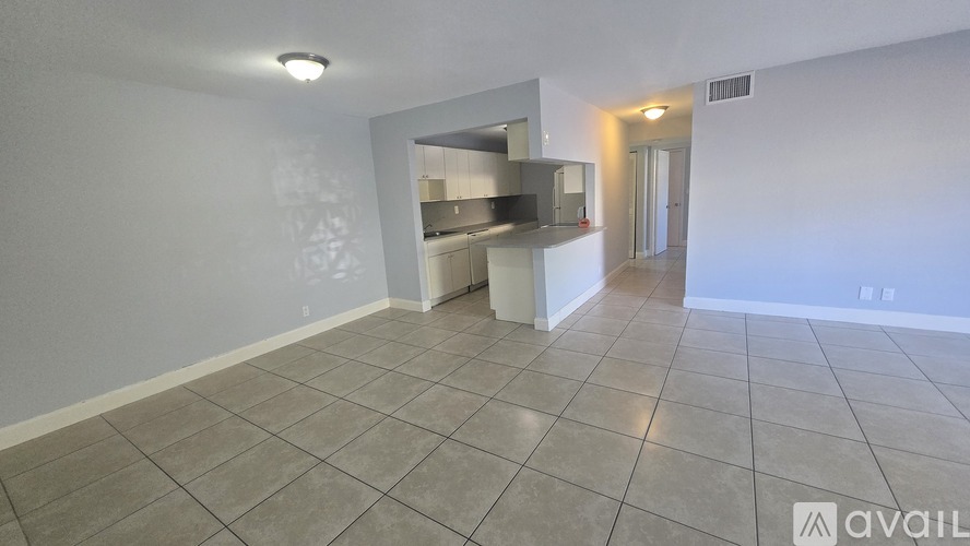 A spacious room with a kitchenette in the corner.