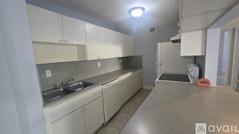 A kitchen with white cabinets and a sink.