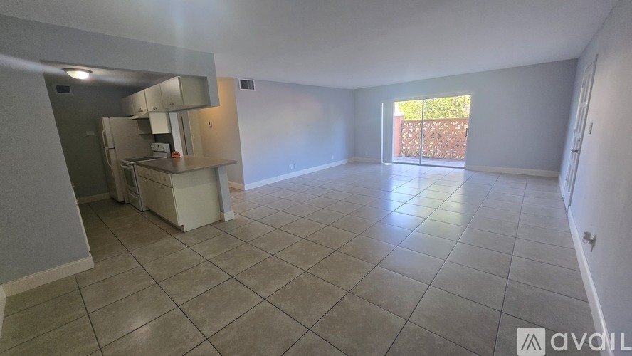 A spacious room with tiled flooring and a large window.