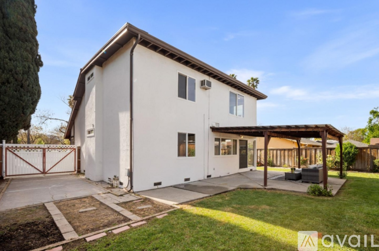 A house with a white exterior and a brown roof is for sale.
