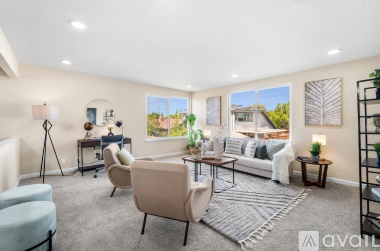 A living room with a sofa, chairs, and a rug.