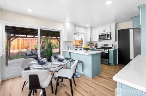 A kitchen with a table and chairs in front of a window.