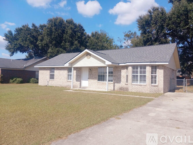 A house with a white door and a grey roof is for sale.