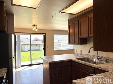 A kitchen with brown cabinets and a granite countertop.