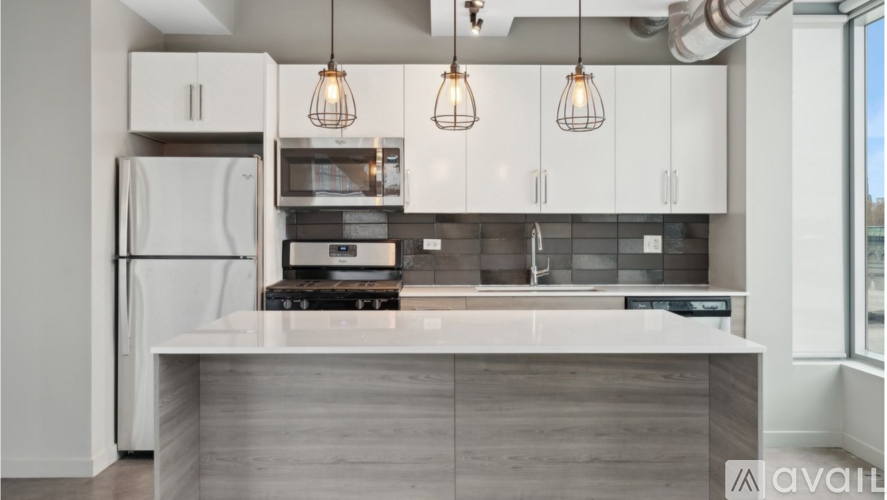 A modern kitchen with a white refrigerator, a microwave, and a stove top oven.