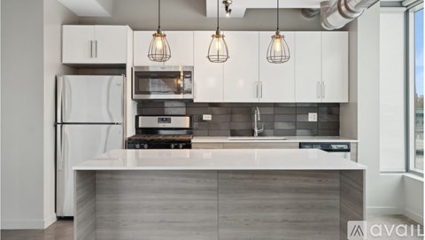 A modern kitchen with a white refrigerator, a microwave, and a stove top oven.