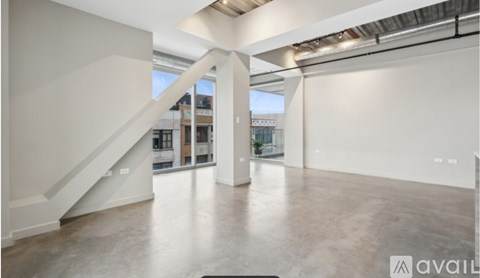 A spacious room with a staircase and a view of the city.